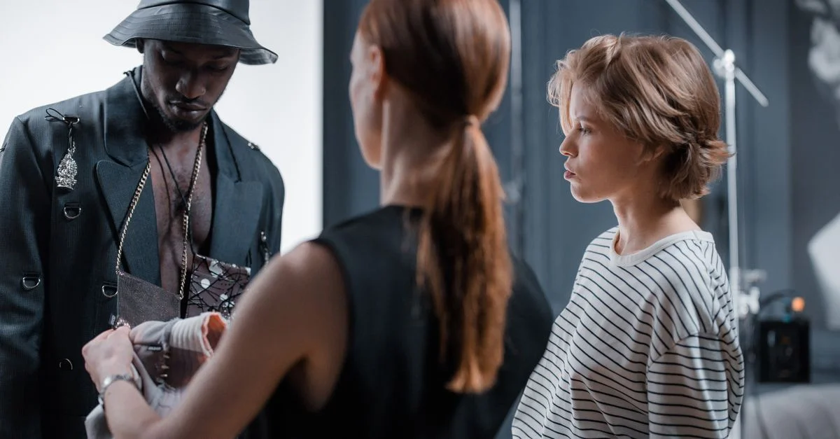 Modèle et équipe se préparant pour une séance photo de mode dans un studio. Créativité en cours.