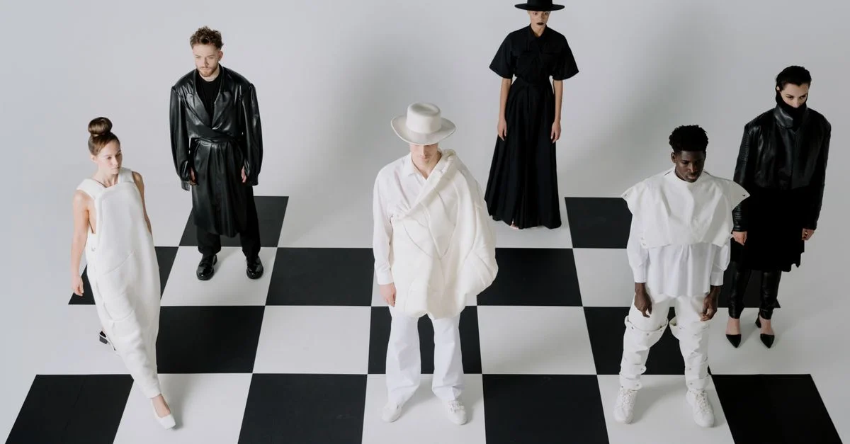 Des mannequins de mode élégants en tenues noir et blanc sur un fond de plateau d'échecs.