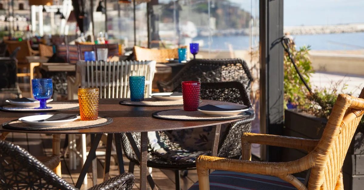 Élégant restaurant en bord de mer avec une vue incroyable sur la terrasse et des verreries vibrantes.